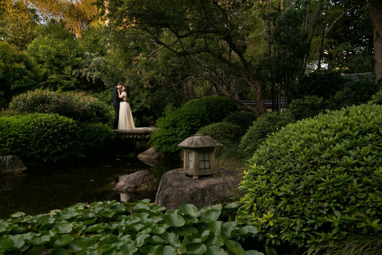 Husband and wife, standing on the Japanese Gardens bridge at Mt Coot-Tha Botanic Gardens