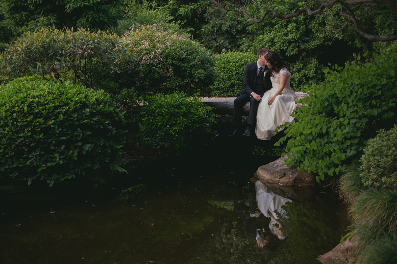 Husband and wife, sitting on the Japanese Gardens bridge at Mt Coot-Tha Botanic Gardens