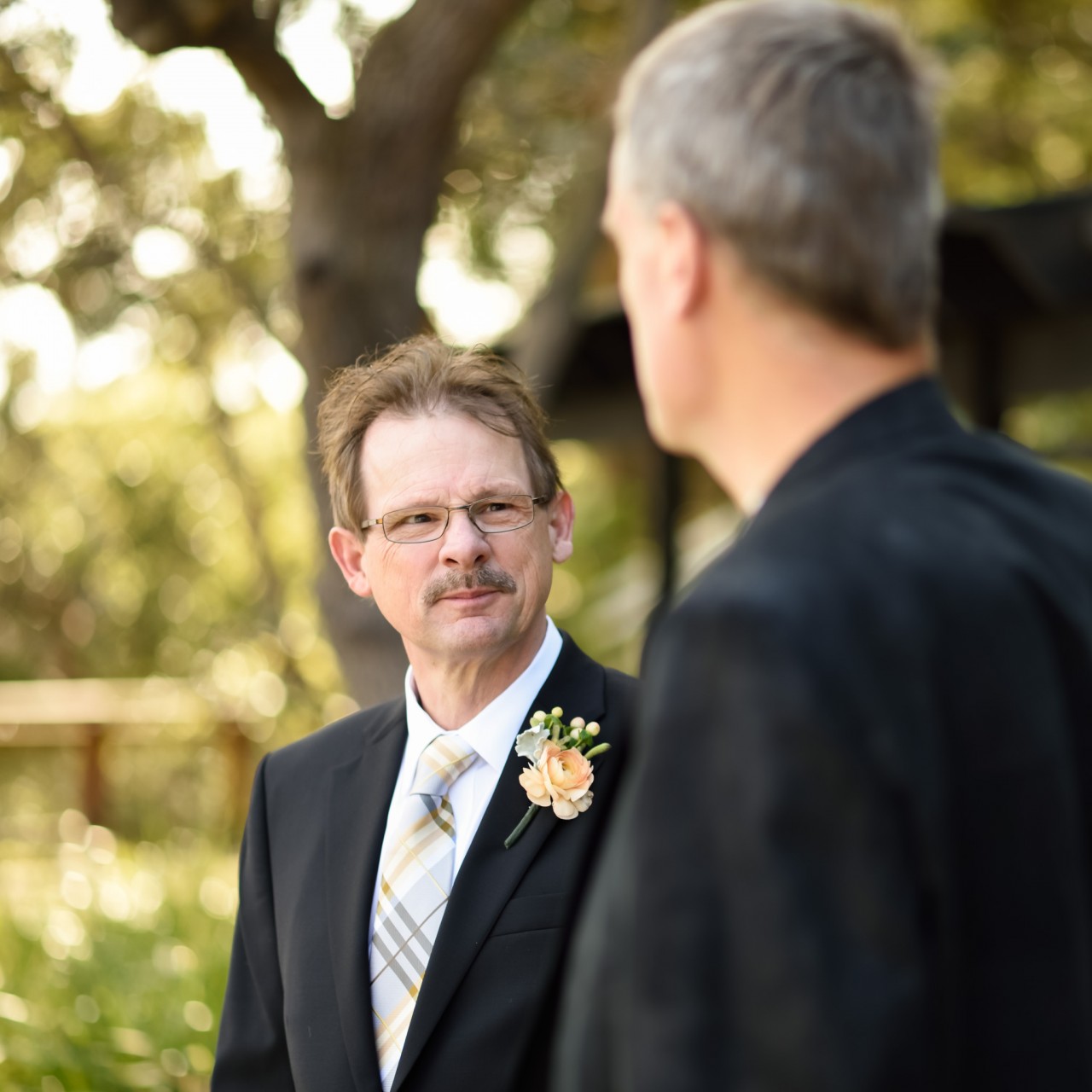 Father of the groom talking to a guest