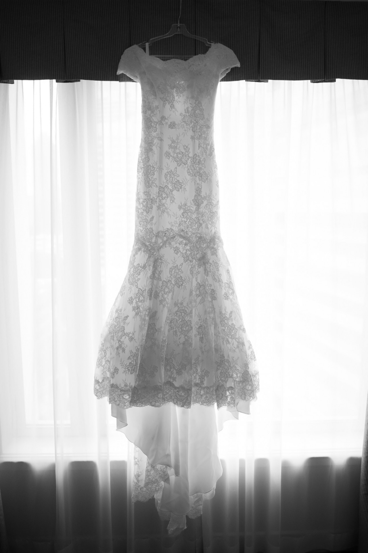 Tish's wedding dress on display backlit in their hotel room at the Marriott Brisbane