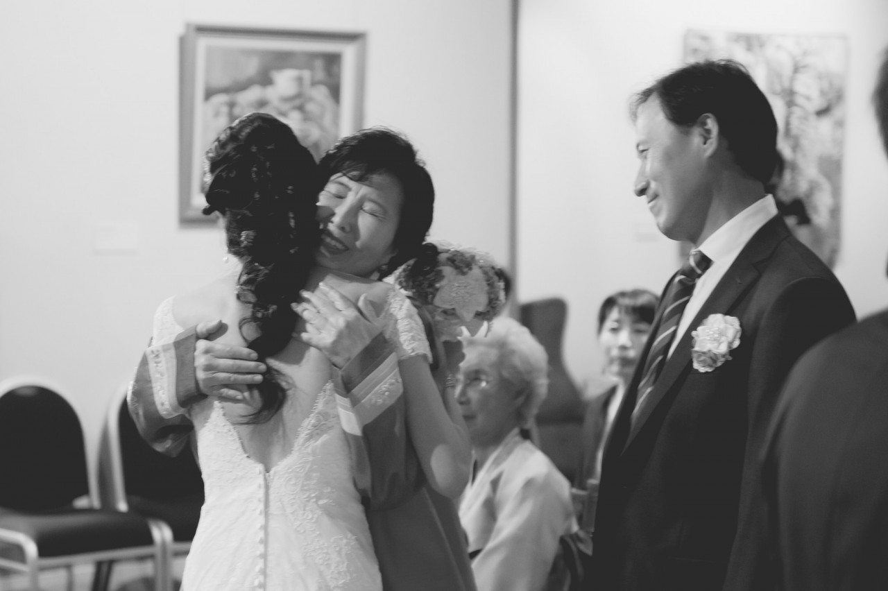 Tish being hugged by her parents in laws after the wedding ceremony