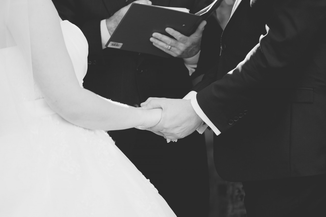 Black and White of Justin the groom holding Melissa's hands