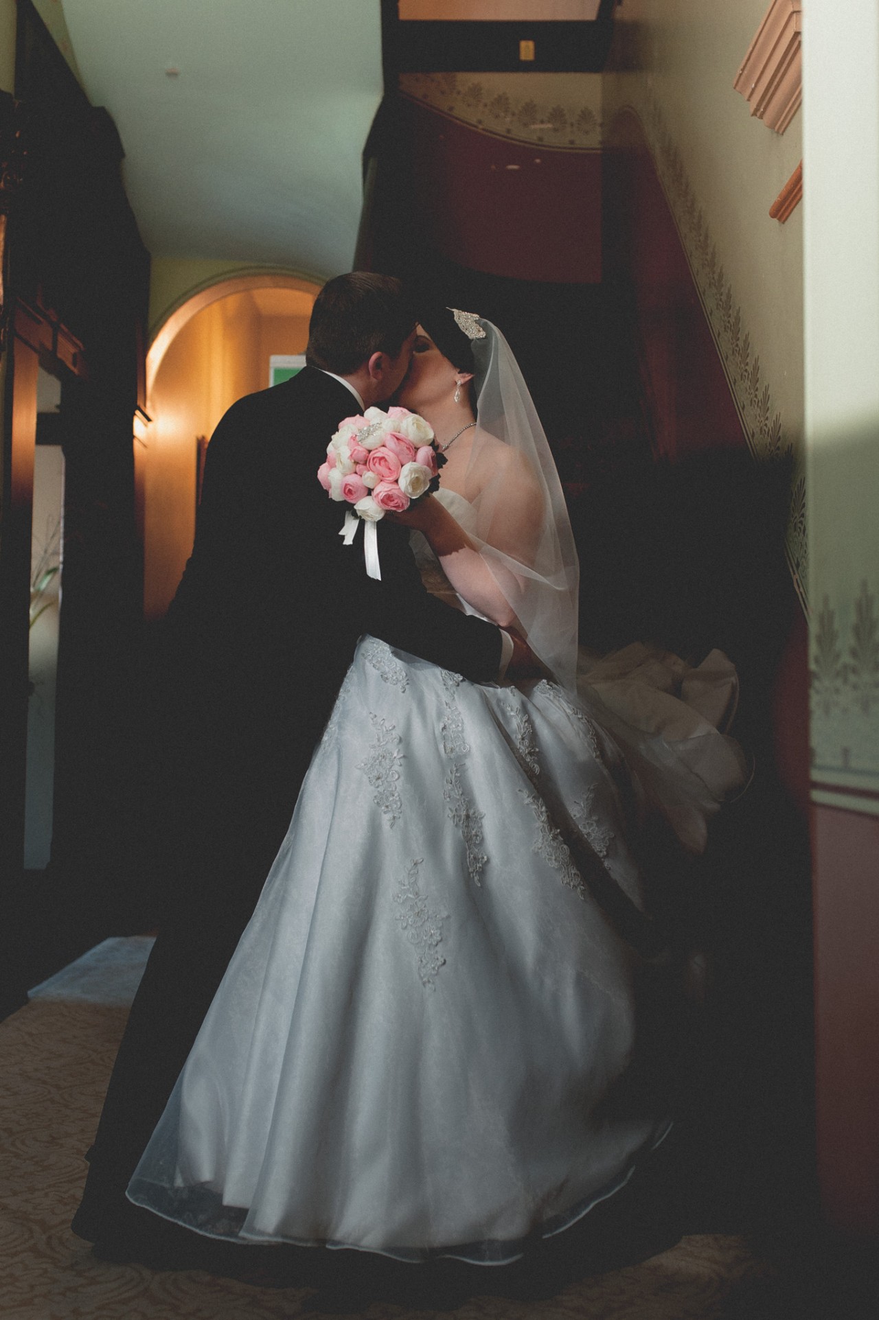 Bride and groom sharing a kiss by a staircase at Shafston House, Kangaroo Point