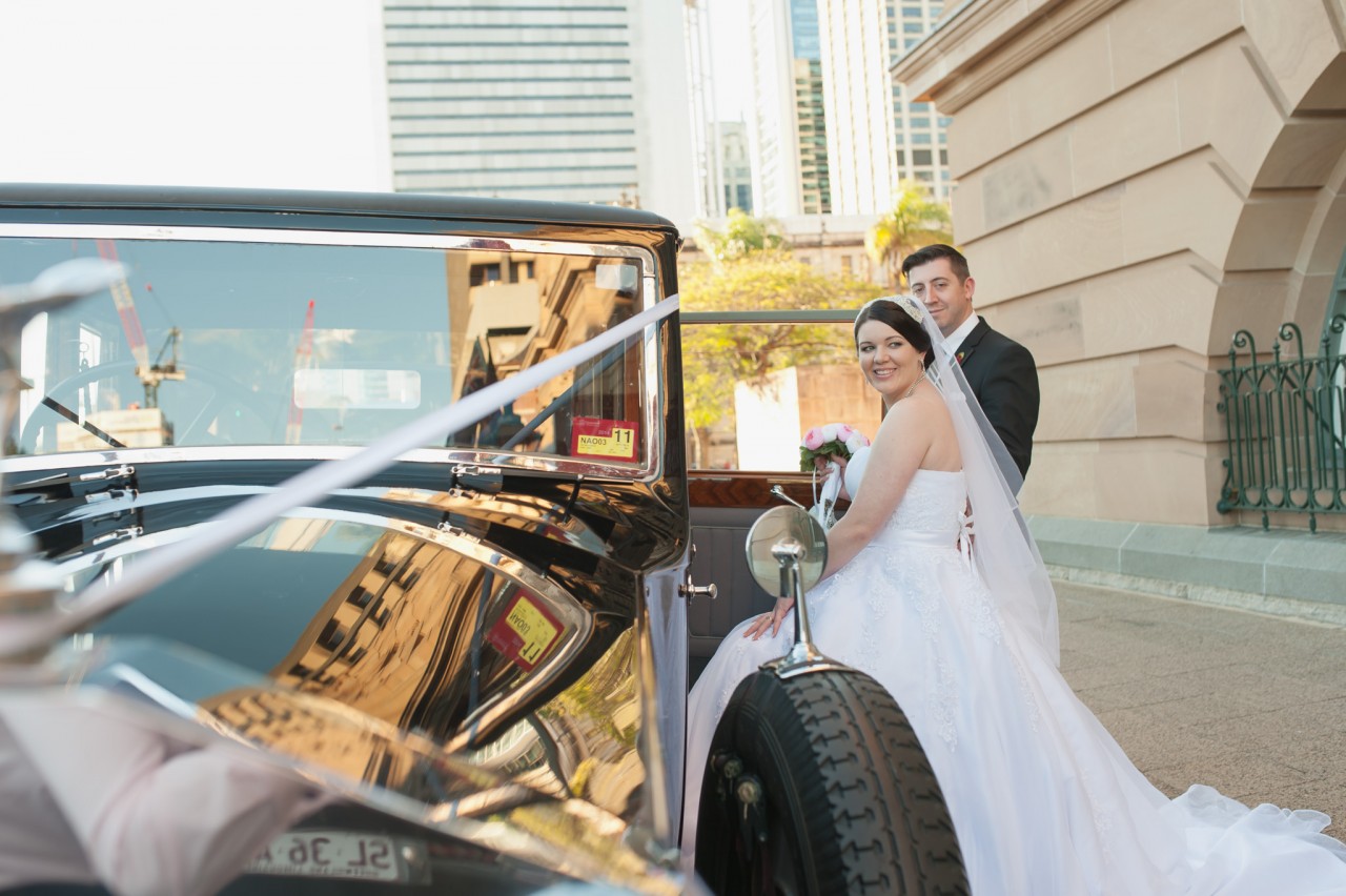 Bride and Groom stepping into their vintage wedding car