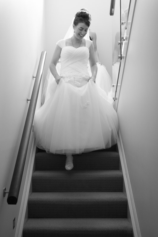 Bride Michaela walking down the stairs in her wedding dress for her family reveal