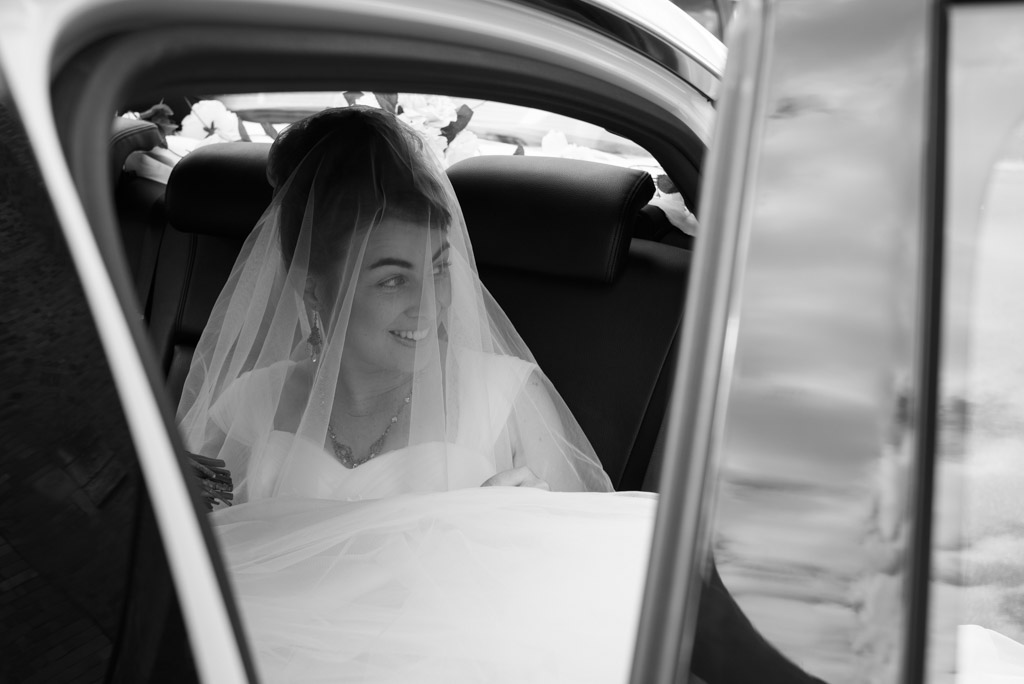 Black and white candid: Bride Michaela about to step out of the car to St Brigid's Church, Red Hill