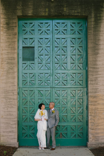 Bride and groom against a teal door
