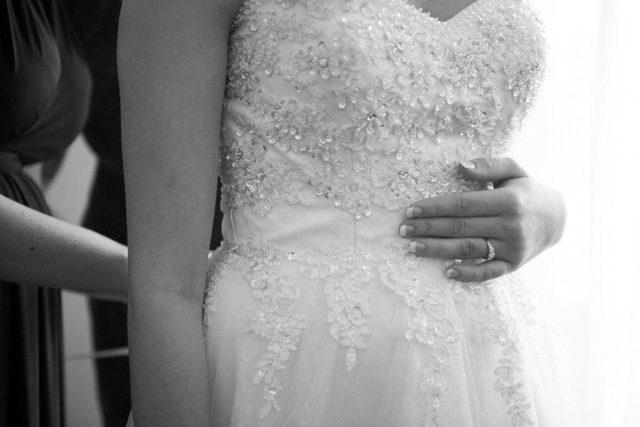 Black and white of Charlotte while putting on the dress