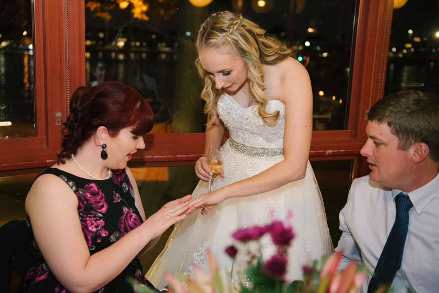 Charlotte the bride showing off her ring to a guest
