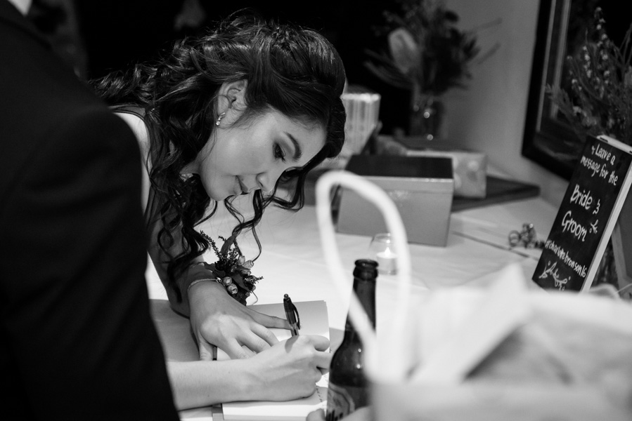Black and white of Samantha signing the guest book
